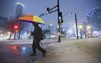 Un hombre camina por una calle nevada en la zona del Centennial Olympic Park Drive, en Atlanta.