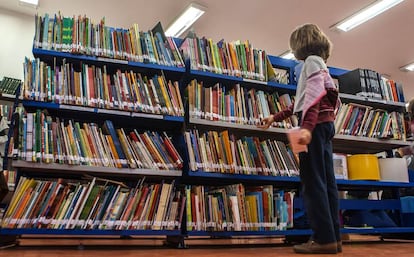 Aluna escolhe livro da biblioteca.