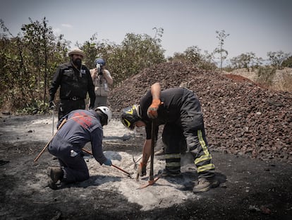 Buscadores y bomberos en el terreno donde se encontró el supuesto crematorio, este 1 de mayo.