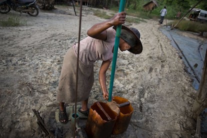 Una mujer extrae petróleo del suelo.