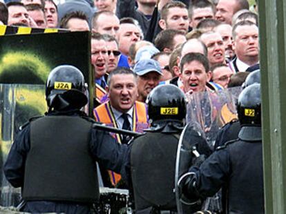 Miembros de la unionista Orden de Orange se enfrentan a la policía el domingo en Portadown.