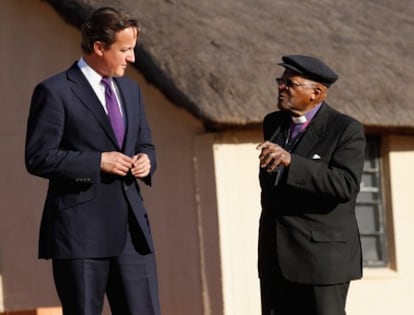 El arzobispo sudafricano Desmond Tutu guía al primer ministro británico, David Cameron, en su visita a Johannesburgo.