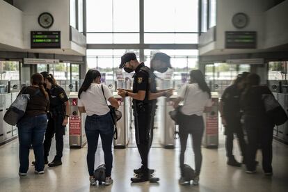 Controles de la Policía Nacional en la estación de tren de Entrevías, en Madrid, para comprobar de manera aleatoria que la gente que usa el tren lo hace por una causa justificada. Desde este lunes, este es uno de los barrios de la capital bajo confinamiento para intentar controlar la pandemia de Covid19