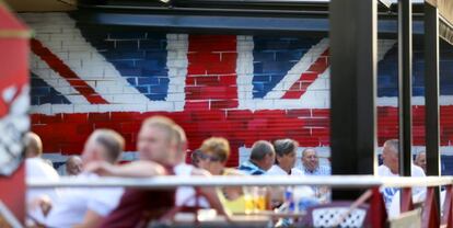 Turistas en una terraza en Benidorm, decorada con la bandera británica.