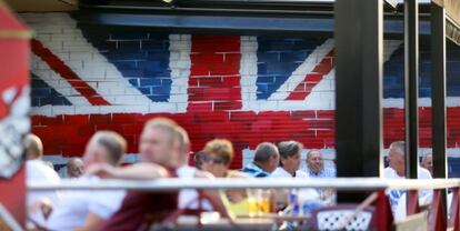 Turistas en una terraza en Benidorm, decorada con la bandera británica. 