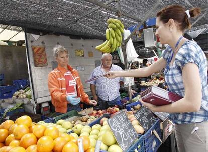 Daniela Varzari reparte folletos sobre los comicios europeos en un mercado de Coslada.