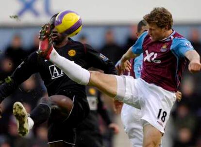 Spector (a la derecha), del West Ham, lucha por el balón con Saha, del Manchester United.