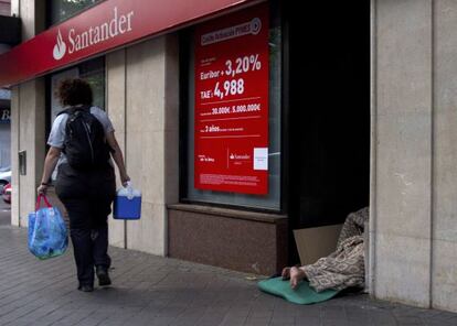 Un hombre duerme en la entrada de un banco en Madrid.