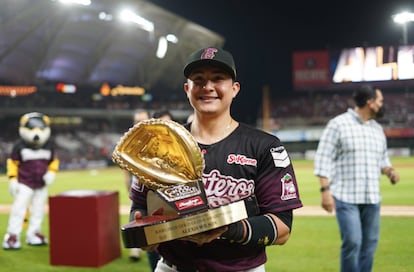 Un jugador de Tomateros de Culiacán exhibe un galardón individual ante la afición del club mexicano de béisbol.