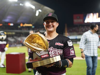 Un jugador de Tomateros de Culiacán exhibe un galardón individual ante la afición del club mexicano de béisbol.