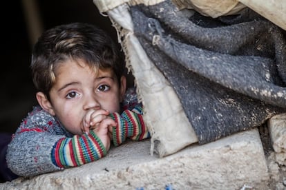 Irak, febrero de 2014. Hakim (nombre ficticio), de tres años, asoma por una carpa gastada en el campo de refugiados de Domiz, en el norte de Irak.