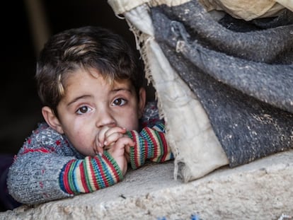 Irak, febrero de 2014. Hakim (nombre ficticio), de tres años, asoma por una carpa gastada en el campo de refugiados de Domiz, en el norte de Irak.