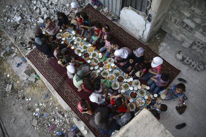 Douma, 20 de junho de 2017. Rodeadas de escombros, meninas encerram o jejum do Ramadã, em uma refeição organizada por uma ONG.