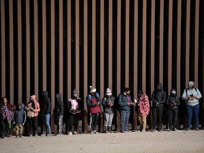 Migrantes en búsqueda de asilo hacen fila para ser procesados por agentes de la Patrulla Fronteriza estadounidense