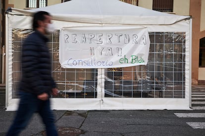 Un hombre camina delante de un cartel de protesta contra el cierre del consultorio médico de Arre en Navarra, el 13 de enero.