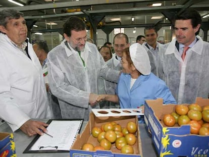 Mariano Rajoy saluda a una trabajadora de una empresa que comercializa tomates en Las Palmas. A la derecha, el presidente del PP de Canarias, José Manuel Soria.