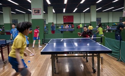 Ni&ntilde;os jugando al tenis de mesa en el centro de Sichahai.