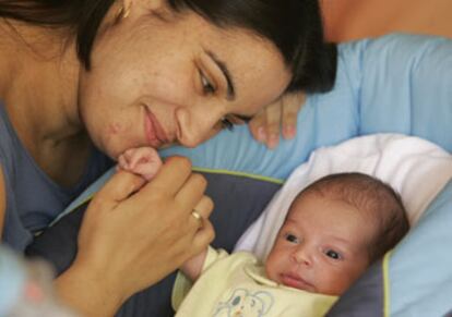 Cristina Mora Palomo, superviviente del 11-M, mira a su hija Arantxa, recién nacida.