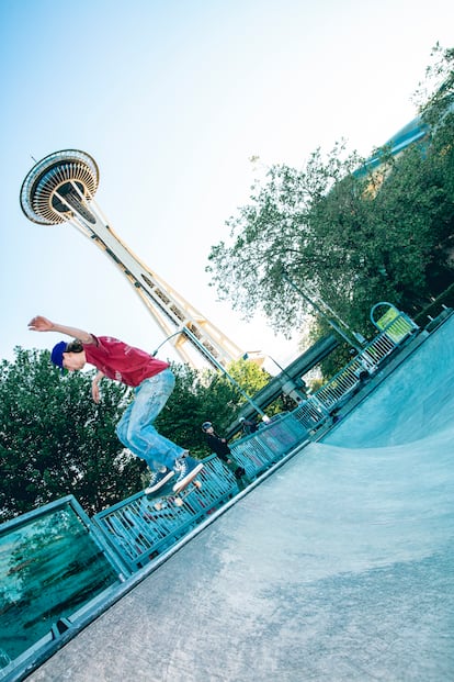 A skateboarder skates in front of the Space Needle, the city's symbol.