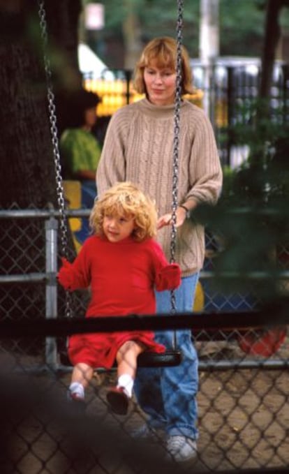 Mia Farrow juega en el parque con su hija adoptiva Dylan en 1990.