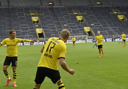 Erling Haaland (en primer término), del Dortmund, celebra el primer gol ante el Schalke 04. De fondo, la impactante imagen del fondo donde antes de la pandemia se levantaba el clásico muro amarillo y ahora resuena el eco.