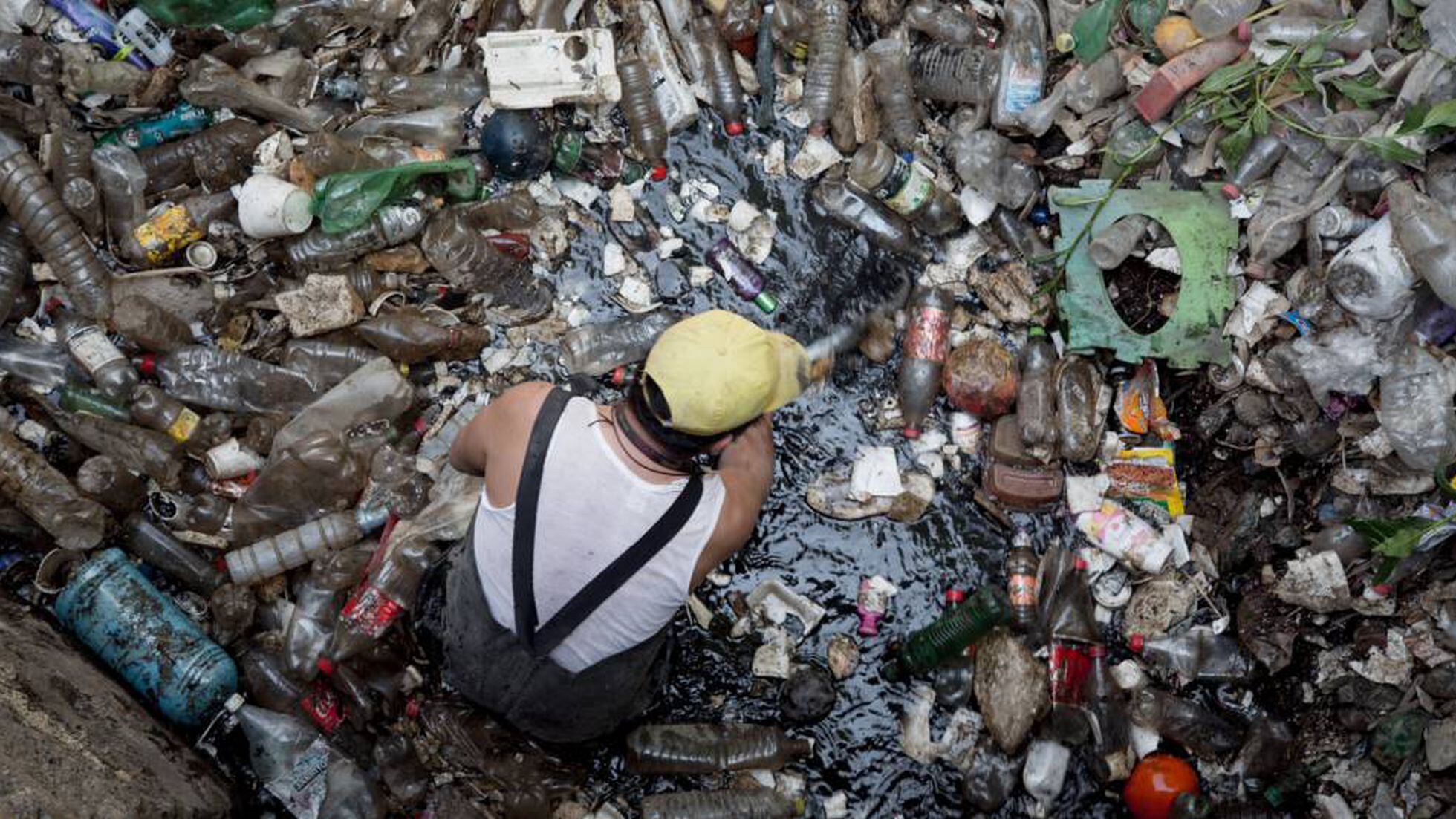 Un trabajador retira plásticos en la presa Mixcoac, en Ciudad de México.