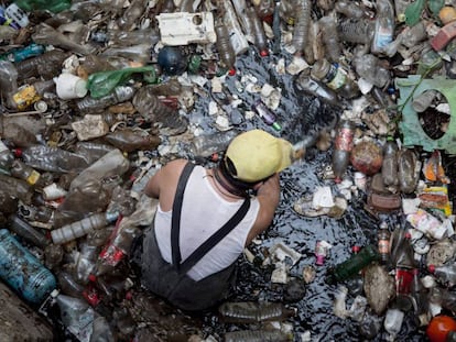 Un trabajador retira plásticos en la presa Mixcoac, en Ciudad de México.