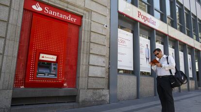 Un cajero del Banco Santander junto a una sucursal del Popular.