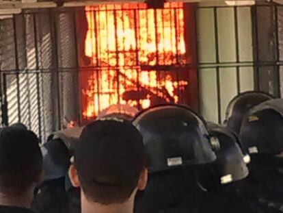 Policiais observam corredor de presídio CPPL IV em chamas durante rebelião.