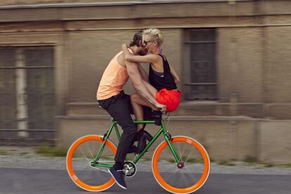 Una pareja monta en una colorida bici por las calles de Berlín.