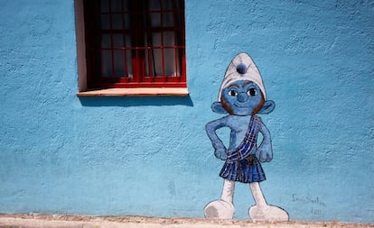 Arriba, un pitufo en una de las calles de Júzcar (Málaga).