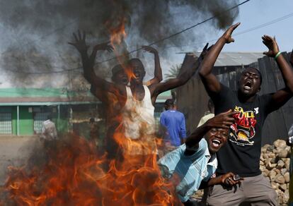 Violentos enfrentamientos entre fuerzas leales al presidente Nkurunziza y militares rebeldes han estallado en la madrugada de este jueves en Buyumbura, la capital de Burundi, un día después de que militares rebeldes encabezados por el general Niyombare perpetraran un golpe de Estado. Los altercados se localizaron en las inmediaciones de los estudios de dos grupos de comunicación, la cadena de televisión pública y una emisora independiente, que difundieron en la jornada del miércoles el anuncio del golpe. Ambos edificios fueron incendiados y saqueados en el ataque. En la imagen, cuatro hombres protestan ante una barricada en Buyumbura este jueves.