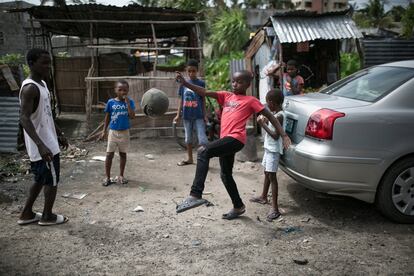 Frente a la vivienda de Tembe, en el barrio de Matacuane, en Beira, un grupo de niños se divierte jugando al fútbol con un balón viejo y roto.