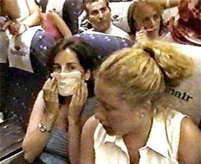 Pasajeros del vuelo de Euro Atlantic Airways se tapan la cara para evitar el hedor a orines durante el viaje.