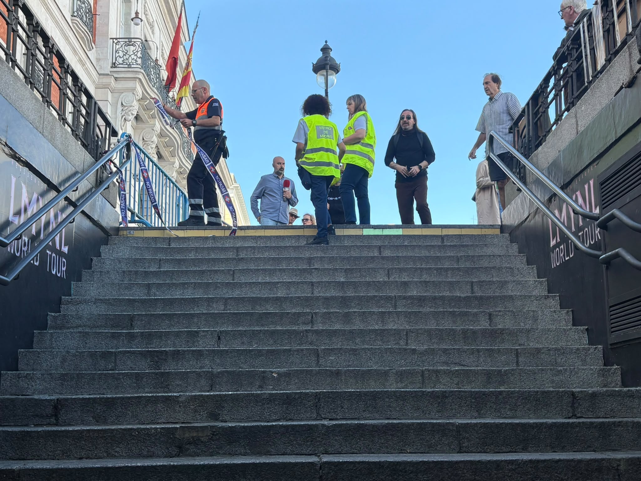 Trabajadores de Metro de Madrid informan a los usuarios del cierre de la estación de Sol, a mediodía de este viernes.