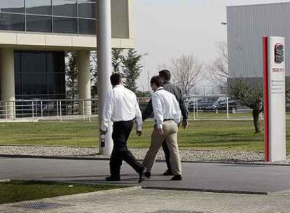 Tres empleados de Seat caminan por el exterior de la planta de Martorell (Barcelona).