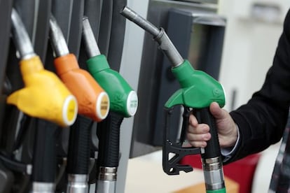 Un home posa gasolina en una estació de servei.