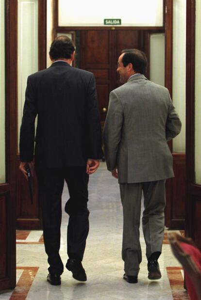 Rajoy y Bono conversan ayer en los pasillos del Congreso.