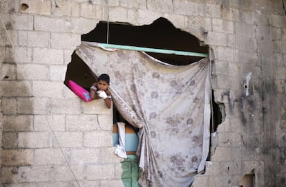 Un niño se asoma por el muro destruido por los bombardeo, en el este de Khan Younis.