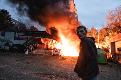 Un hombre pasa junto a un incendio provocado por el ataque aéreo ruso sobre Kiev.
