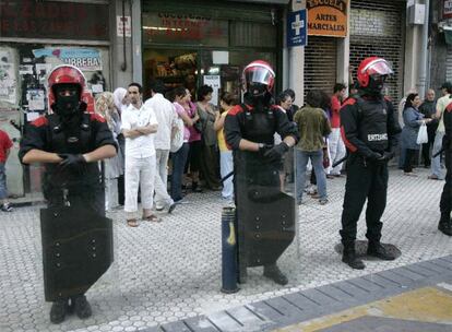 Varios <i>ertzainas</i> vigilan la manifestación contra la inseguridad en el barrio de Iztieta, en Rentería.