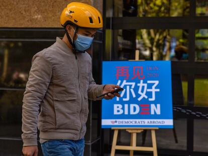 Entregador passa em frente a um bar de Xangai que exibiu a apuração das eleições norte-americanas.