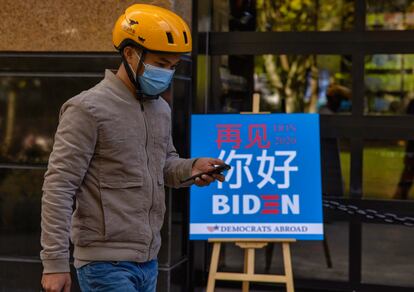 Entregador passa em frente a um bar de Xangai que exibiu a apuração das eleições norte-americanas.