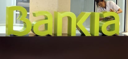 Una operaria limpia el logo de Bankia. EFE/Archivo