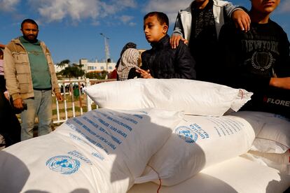 Niños palestinos sobre unos sacos de harina distribuidos por la UNRWA en Rafah, Gaza, el 21 de noviembre de 2023.