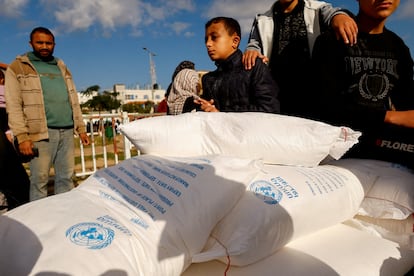 Niños palestinos sobre unos sacos de harina distribuidos por la UNRWA en Rafah, Gaza, el 21 de noviembre de 2023.