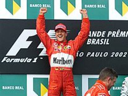 Michael Schumacher celebra en el podio su victoria ante el director técnico de su equipo, Ross Brawn.