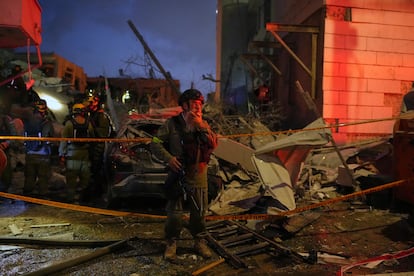 Fuerzas de seguridad inspeccionan los daños causados en varios edificio tras ser alcanzados por misiles lanzados desde  Irán en las cercanías de Tel Aviv, este domingo.