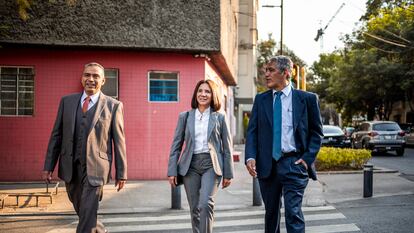 Tres oficinistas caminan en una calle en Ciudad de México.