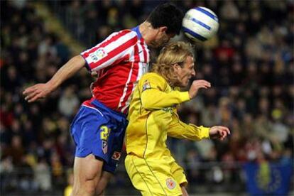 El jugador del Villarreal Diego Forlán salta por un balón con Pablo, del Atlético de Madrid.